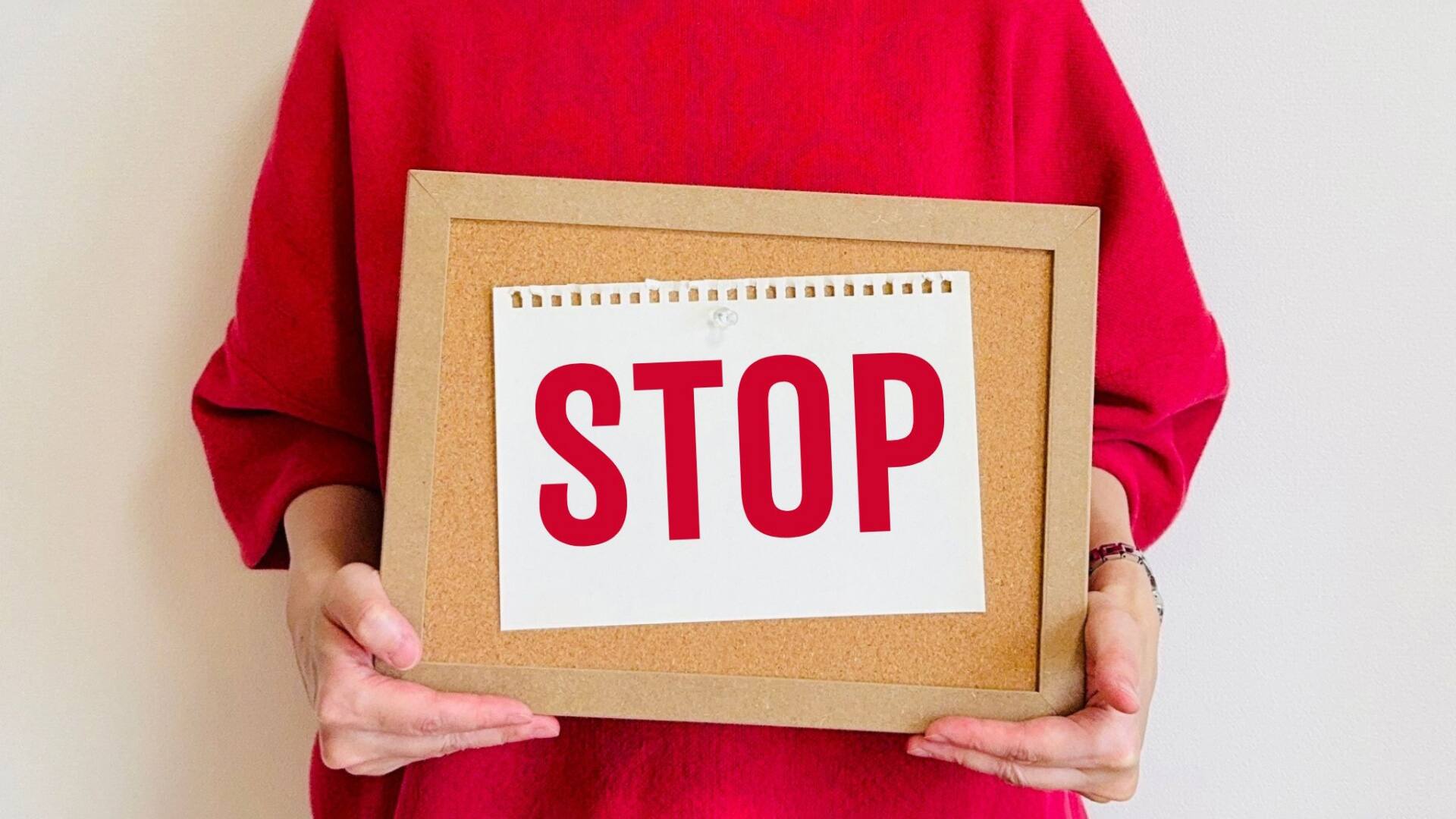 STOPと書かれたボードを持つ女性