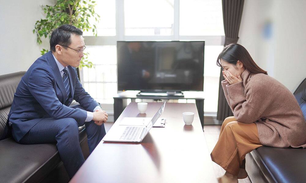 依頼人の話を聞く興信所の探偵